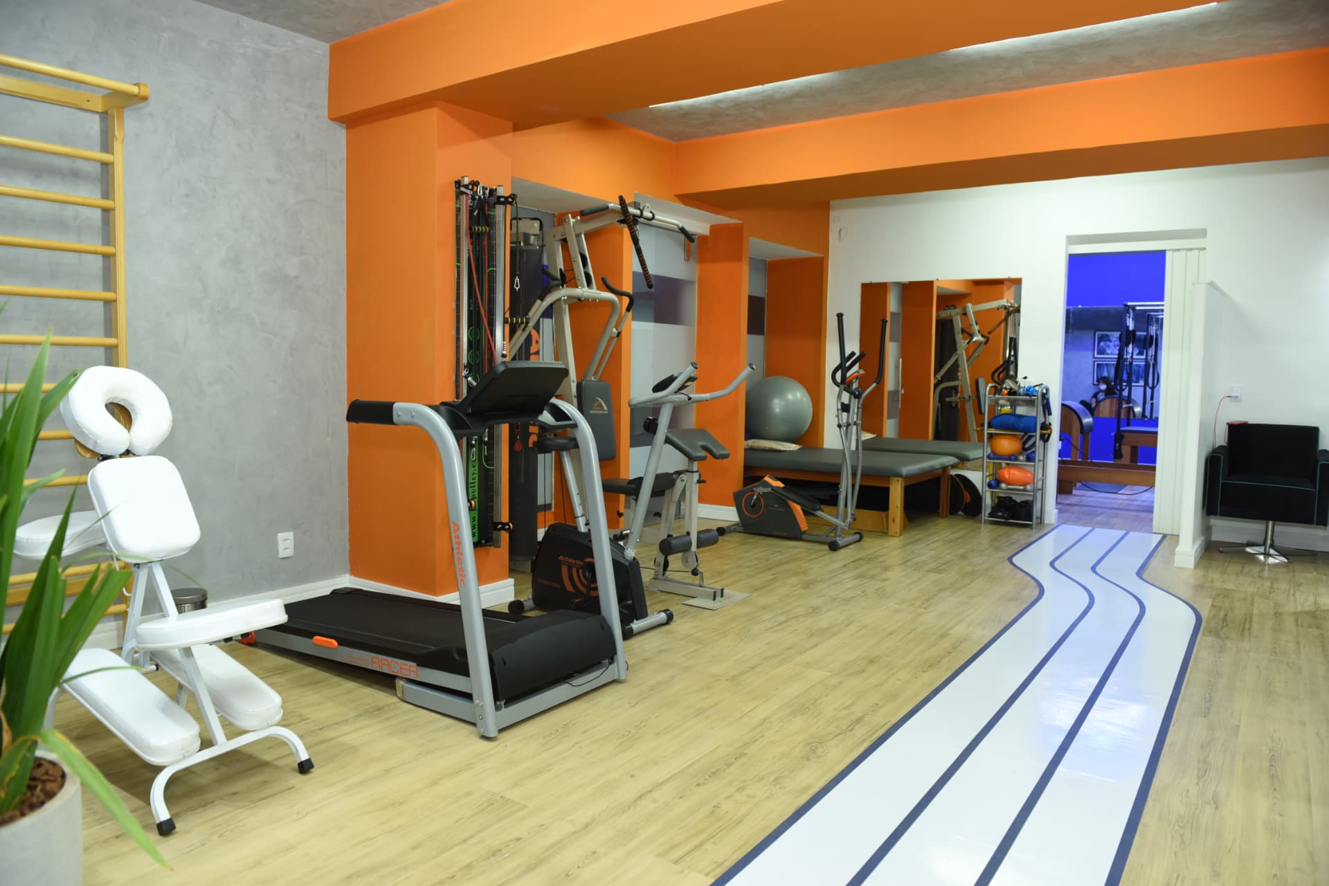Sala de fisioterapia da Clínica Vita Center com esteira, aparelhos de musculação, bola suíça e barra de exercícios